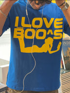 Person wearing a blue t-shirt with yellow text and graphics in an indoor setting.
