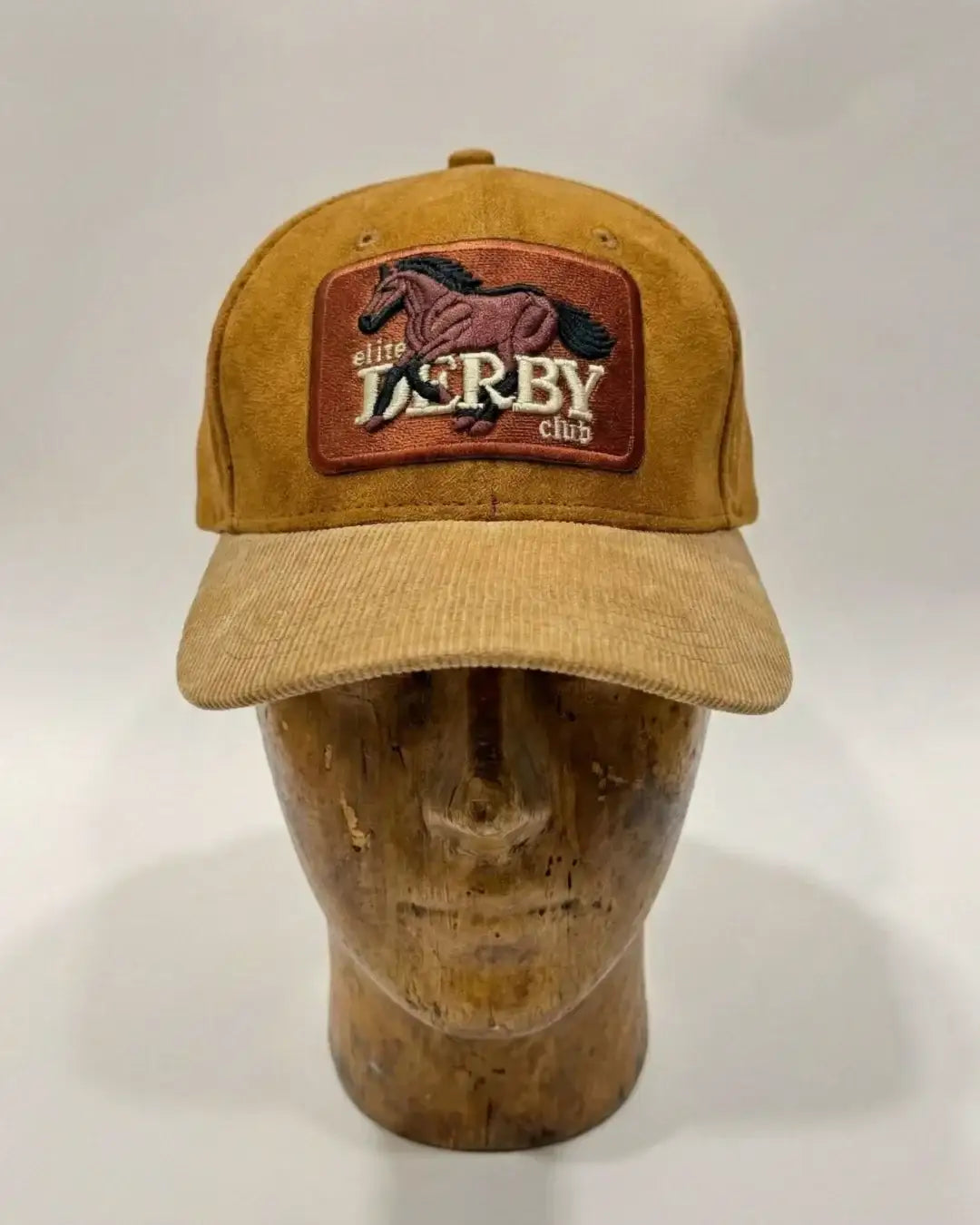 teeside tan derby club cap with horse patch on wooden mannequin
