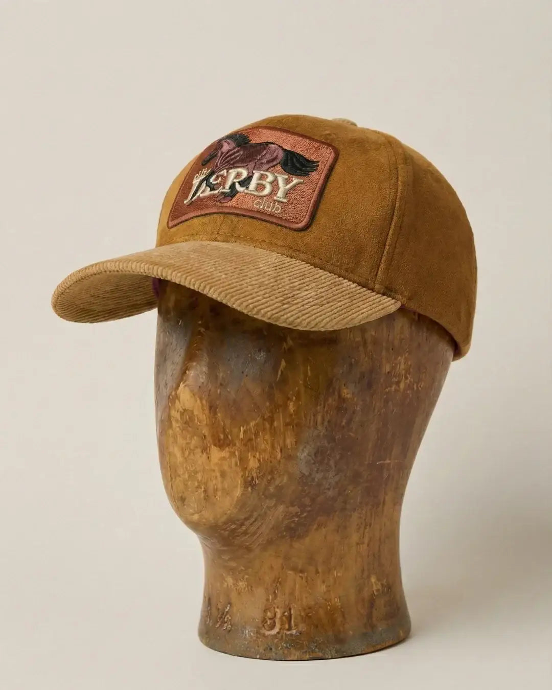 teeside brown suede cap with Derby club horse patch on display mannequin