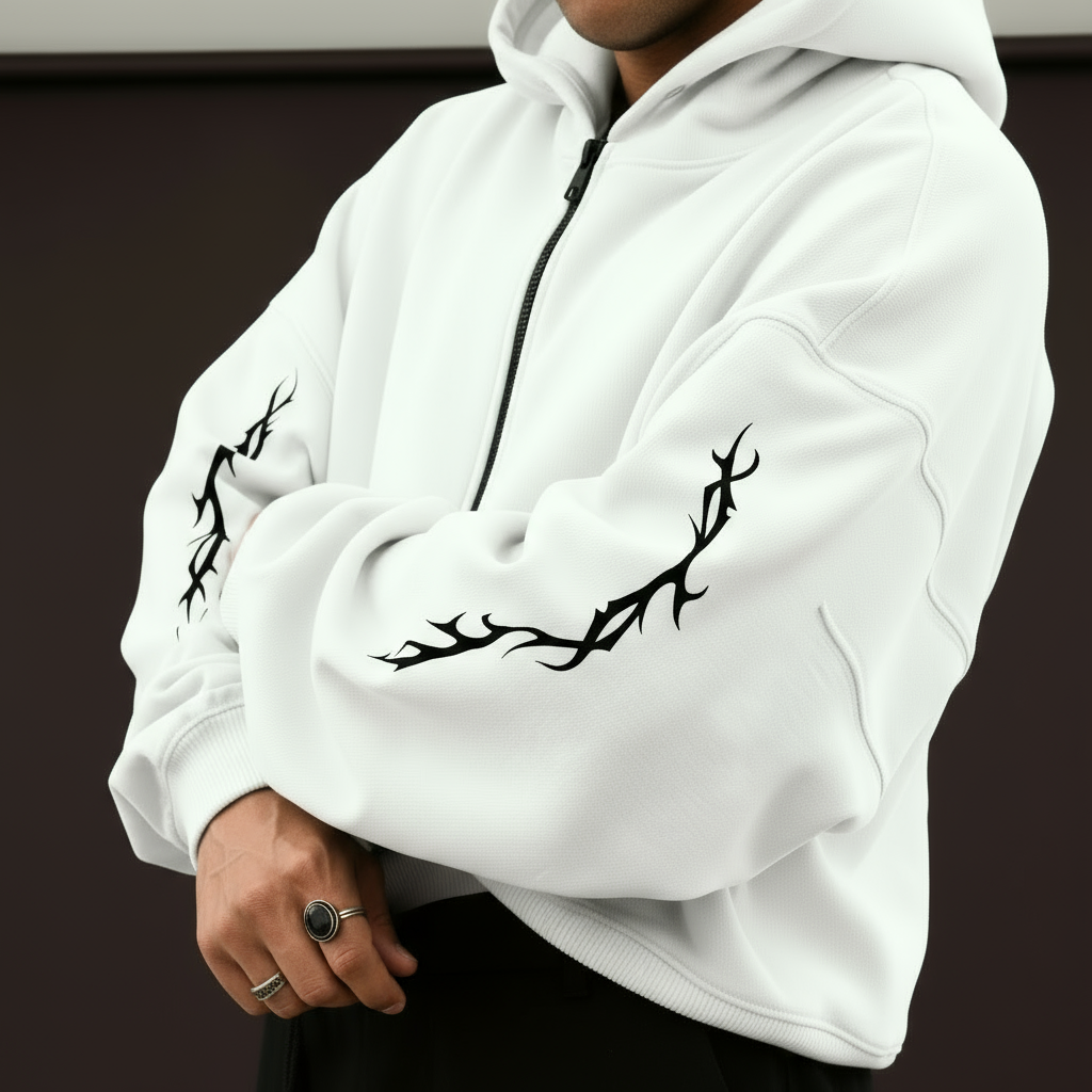 White hoodie with black tribal designs on sleeves against a dark background